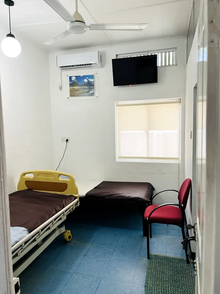 Private patient room with hospital bed and seating
